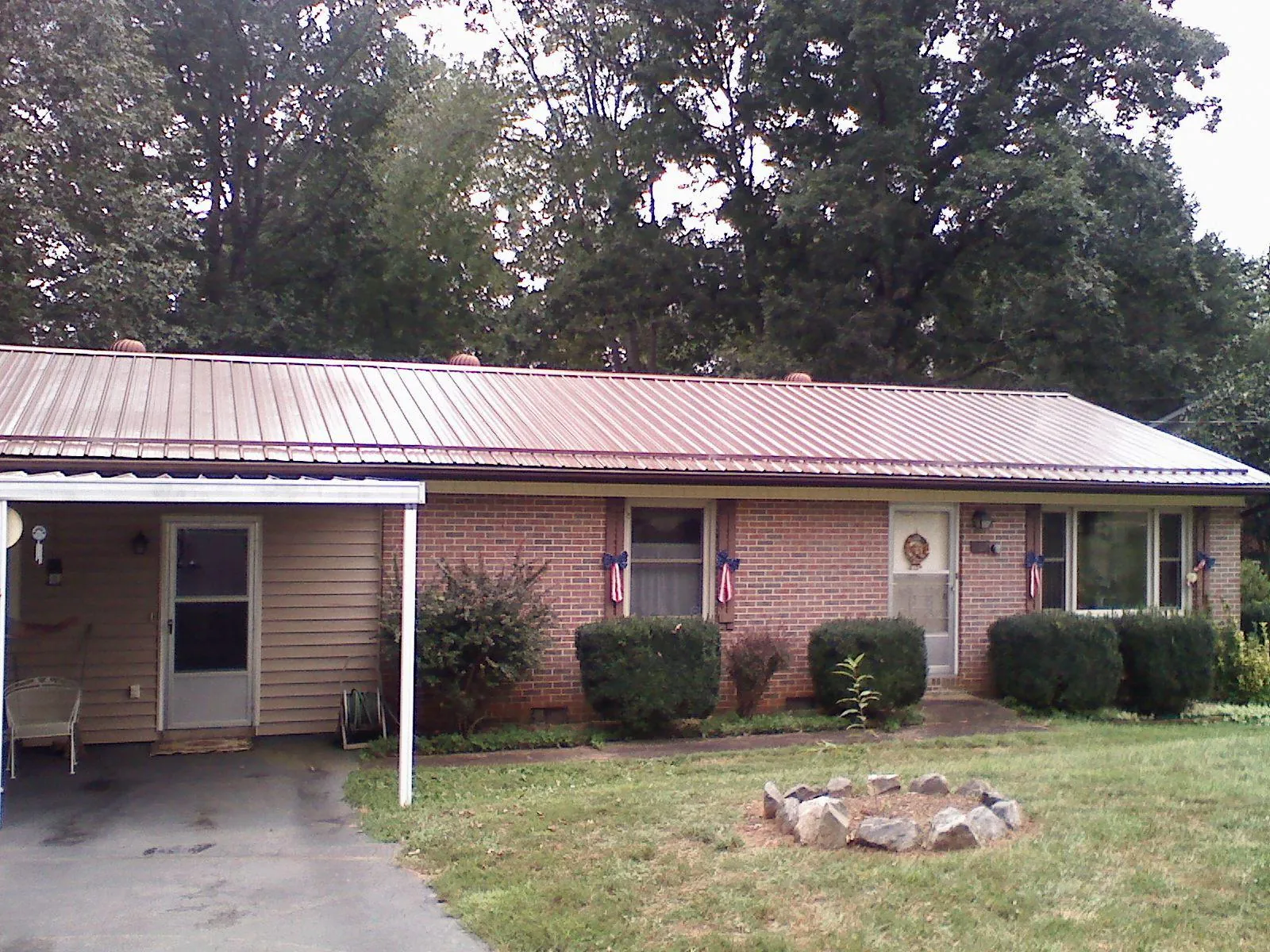 Bronze metal roof and carport on a brick ranch home — Roof Repair work by our crew in Avon